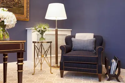 a blue living room with a chair and a lamp at Trump Turnberry in Turnberry