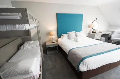 a bedroom with two bunk beds and a desk at Crown Hotel Wetheral in Carlisle