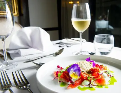 a plate of food on a table with a glass of wine at Crown Hotel Wetheral in Carlisle