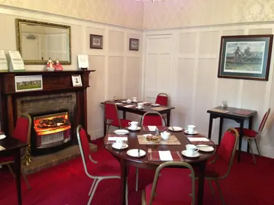 a dining room with tables and a fireplace at Inverlea Guest House in Ayr