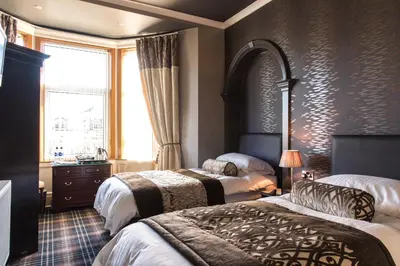 a hotel room with two beds and a window at Inverlea Guest House in Ayr