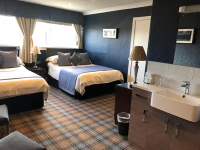 a hotel room with two beds and a sink at Inverlea Guest House in Ayr