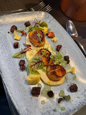 a plate of food with meat and vegetables on it at The Ship Inn - Winner Best Hotel Experience 2024 Visit Scotland in Gatehouse of Fleet