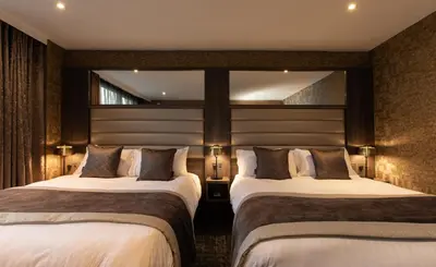a hotel room with two beds and a window at Carlton Hotel in Prestwick