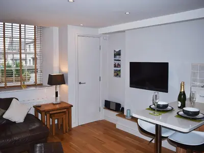 a living room with a table and a tv at Chaucers Nook in Keswick