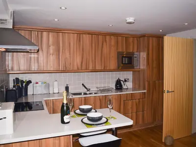 a kitchen with wooden cabinets and a white counter top at Chaucers Nook in Keswick