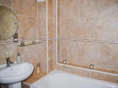 a bathroom with a sink and a toilet and a mirror at Chaucers Nook in Keswick