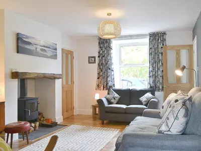 a living room with a couch and a fireplace at 3 Barf Cottages in Portinscale