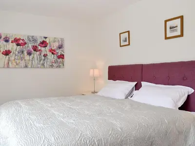 a bedroom with a bed and a painting on the wall at 3 Barf Cottages in Portinscale