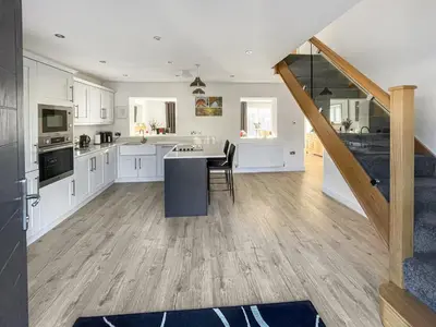 a kitchen with white cabinets and a table with chairs at Causey View in Keswick