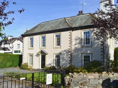 an old white house with a gate in front of it at Oak Apple House in Keswick