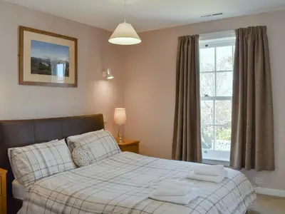 a bedroom with a bed and a window at Oak Apple House in Keswick