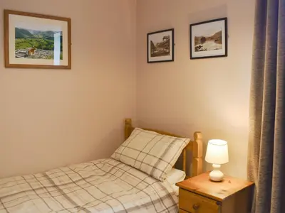 a bedroom with a bed and two pictures on the wall at Oak Apple House in Keswick