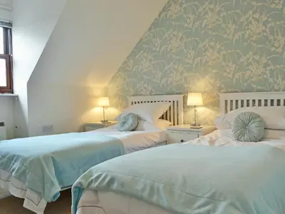 a bedroom with two beds with blue and white at Herdwick Heights in Keswick