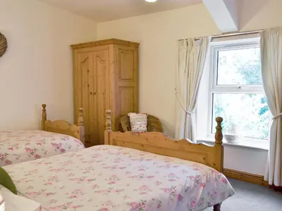 a bedroom with two beds and a window at Harriet's Hideaway in Braithwaite