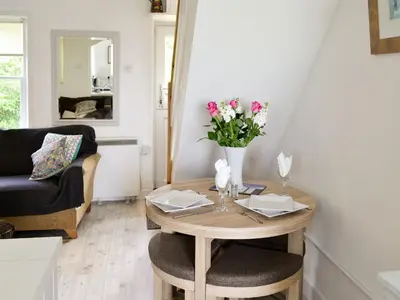 a living room with a table with flowers on it at Shore Cottage in Carsluith