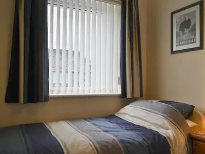a bedroom with a bed in front of a window at Heatherside in Portinscale