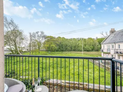 a balcony with a view of a green field at Harbour Retreat in Garlieston