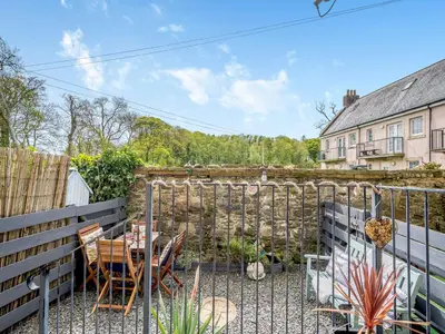 a patio with a table and chairs and a fence at Harbour Retreat in Garlieston