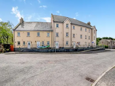 a large building with a fence in front of it at Harbour Retreat in Garlieston
