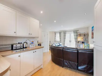 a kitchen with a leather couch in the middle at Harbour Retreat in Garlieston