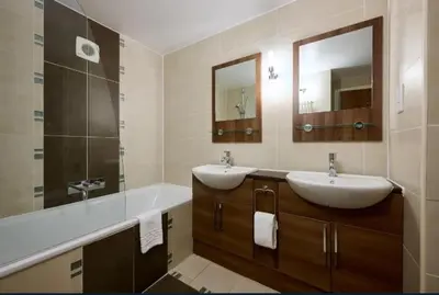 a bathroom with two sinks and a large mirror at Fell View in Troutbeck