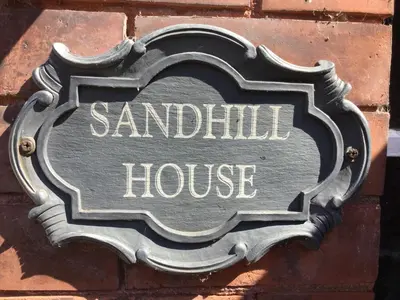 a sign for a sandwich house on a brick wall at Sandhill House in Troon