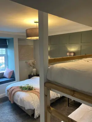 a bedroom with two bunk beds and a couch at Abbey Court Guest House in Carlisle