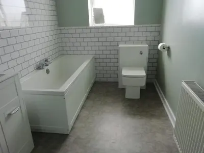 a white bathroom with a tub and a toilet at Old Station House - Kilfillan Cottage in Garlieston