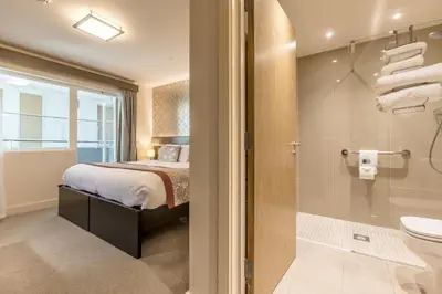 a bedroom with a bed and a bathroom with a shower at Mannin Hotel in Douglas