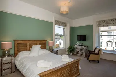 a bedroom with a large bed with towels on it at Baie Mooar House, Boutique B&B in Ramsey