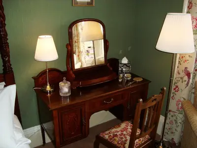 a bedroom with a dressing table with a mirror on it at Lochinver Guesthouse in Ayr