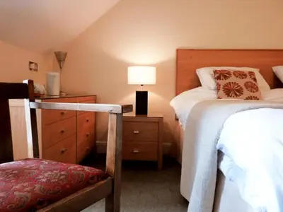 a bedroom with a bed and a dresser with a lamp at The Douglas Hotel in Langholm