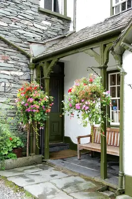 an entrance to a house with two potted plants and a bench at The Old Dungeon Ghyll Hotel in Great Langdale