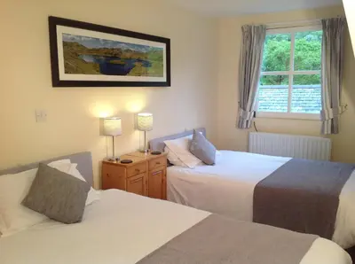 a bedroom with two beds and a window at Old Water View in Patterdale