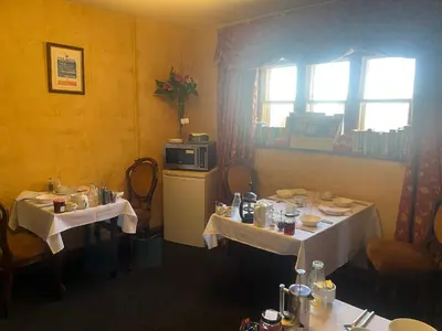 a dining room with two tables and a microwave at Lulus in St Bees