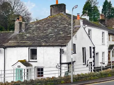 an old white house on the side of a street at Cosy Cottage in Portinscale
