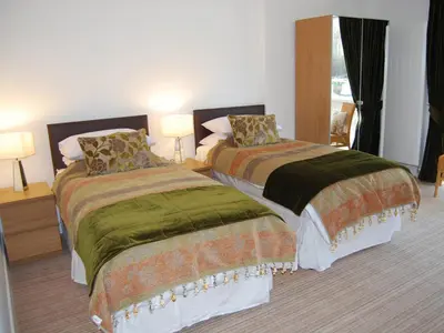two beds in a hotel room with two lamps at Island View in Dunure