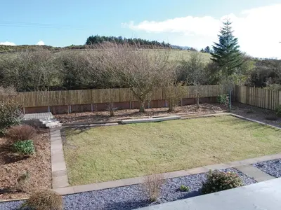 a backyard with a fence and a yard withgrass at Island View in Dunure
