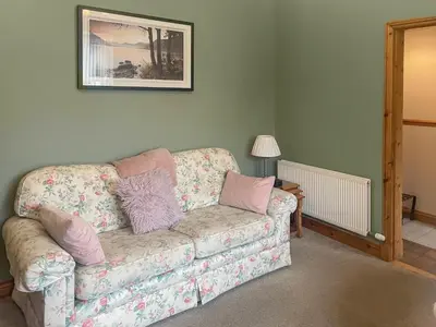 a living room with a couch with pillows on it at Bay Cottage in Keswick