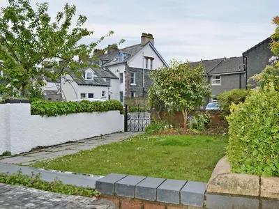 a yard with a white fence and houses at Bay Cottage in Keswick