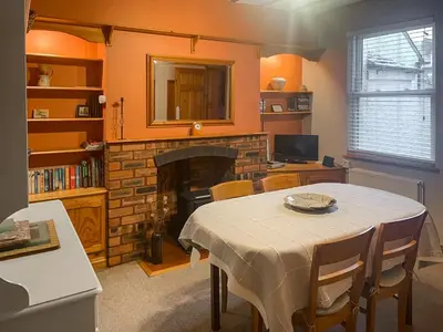 a dining room with a table and a fireplace at Bay Cottage in Keswick