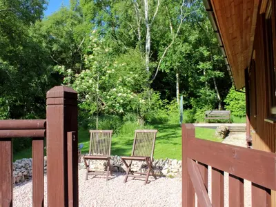 two chairs sitting in a yard next to a fence at Rowanburn Lodge in Ellonby