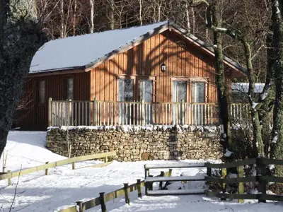 a log cabin in the snow with a fence at Rowanburn Lodge in Ellonby