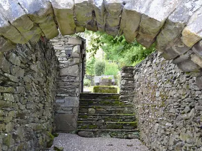 an archway in a stone wall with a window at Ingle Neuk Cottage in Mosedale