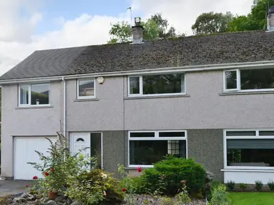 a gray house with white windows and a garage at Briar Rigg in Keswick