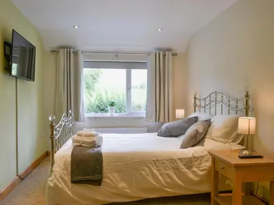 a bedroom with a large bed and a window at Briar Rigg in Keswick