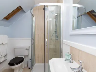 a bathroom with a shower and a sink and a toilet at One The Stables in Dalrymple