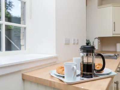 a coffee maker and croissants on a counter in a kitchen at One The Stables in Dalrymple