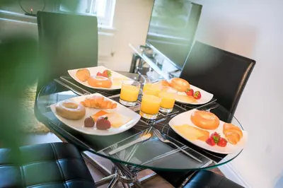 a table with plates of food and glasses of orange juice at Church View Irene Court Cockermouth in Cockermouth